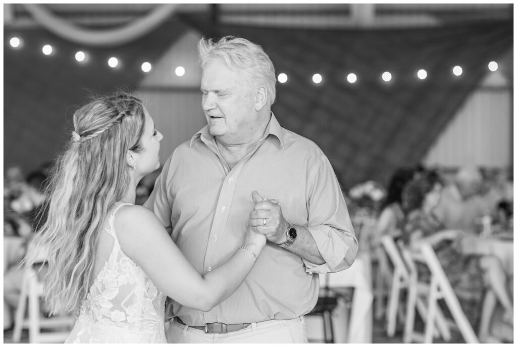 bride having a dance with her dad at wedding reception in metal barn