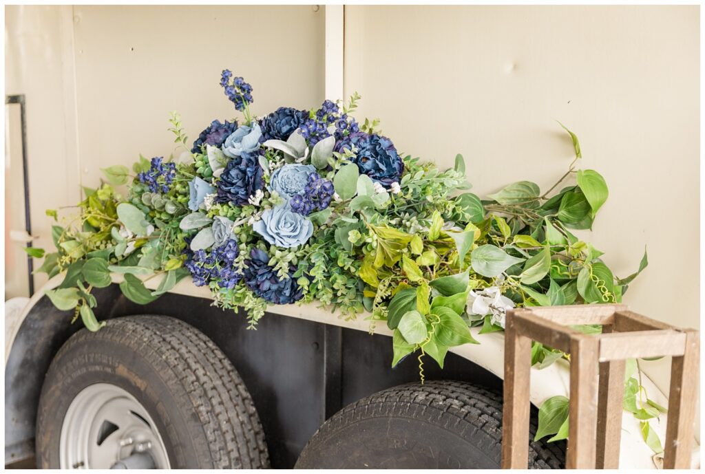 large blue and green floral decoration sitting on top of the wheels of mobile bar