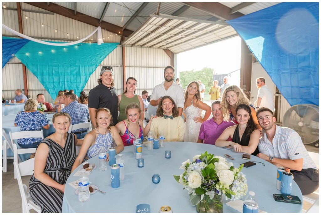 bride and groom posing behind a table of wedding guests at Ohio reception