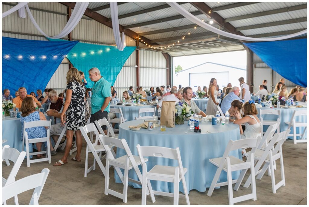 reception room decorated with blue and green tarps and blue tablecloths