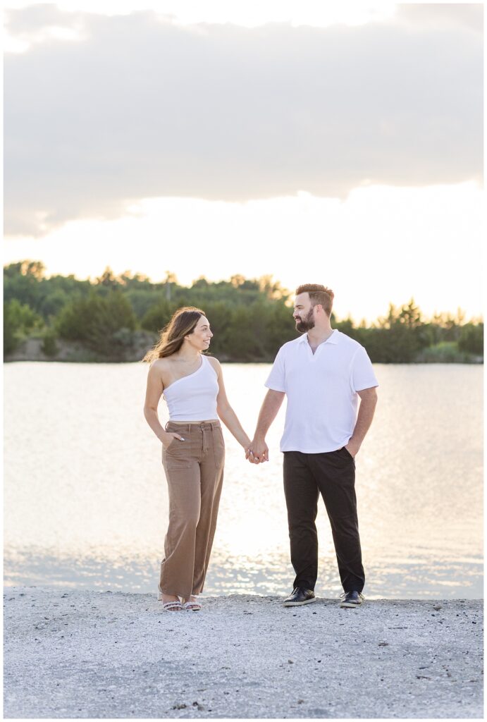 engaged couple holding hands on the sand at Silver Rock Quarry