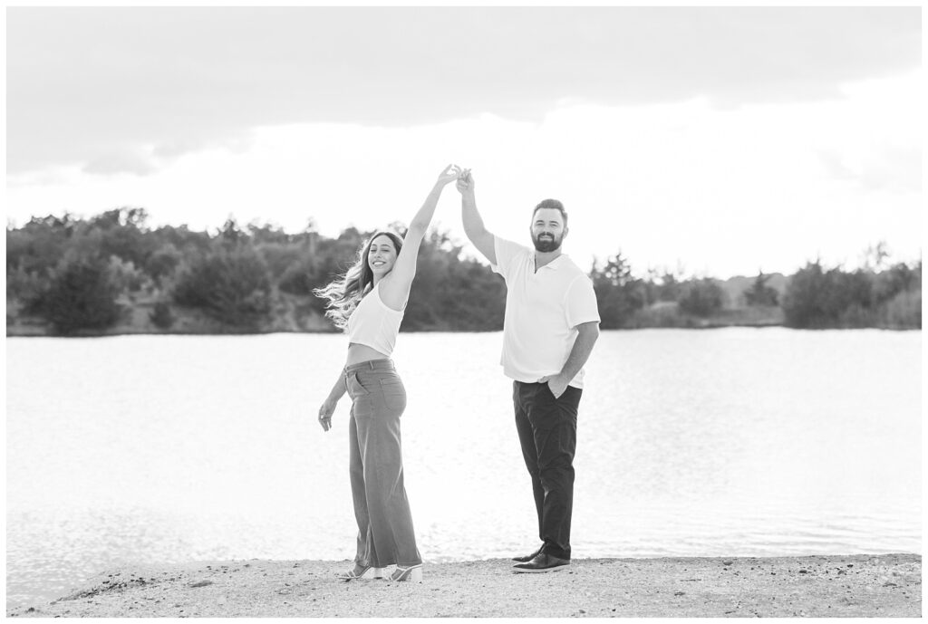 man twirling his fiance on the beach at Gibsonburg, Ohio engagement session