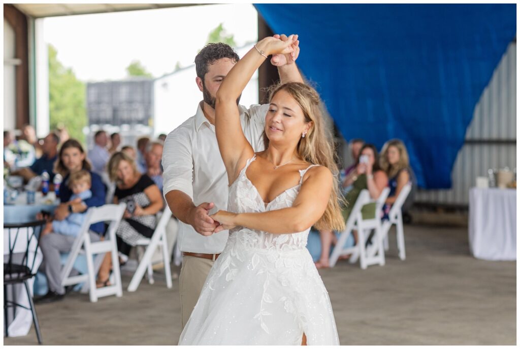 groom twirling the bride during first dance at country wedding reception in Ohio