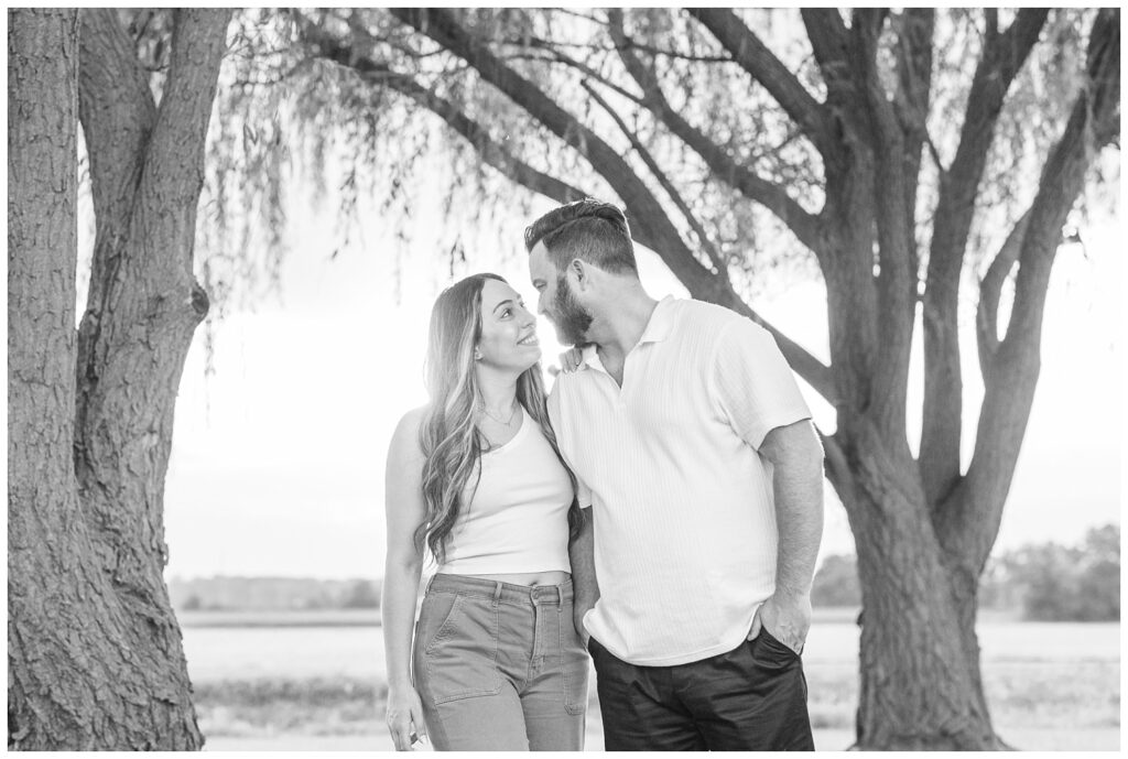 engagement couple standing under some trees in Gibsonburg, Ohio