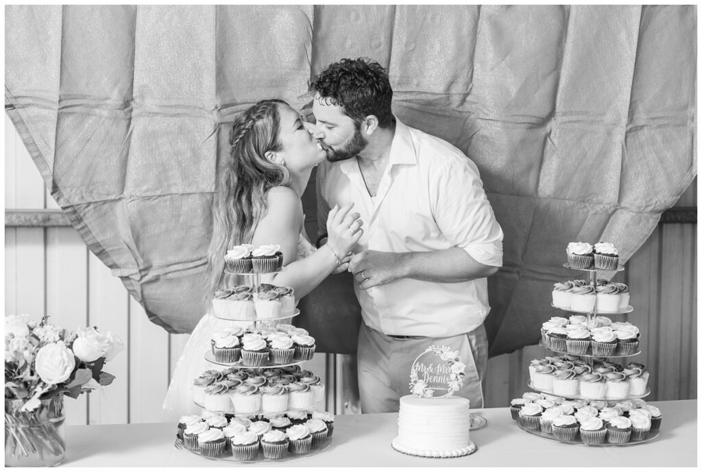 bride and groom kissing after cutting the wedding cake at Risingsun, Ohio reception