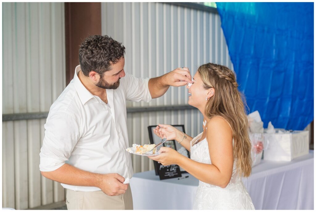 groom wiping wedding cake from the bride's face at Ohio reception