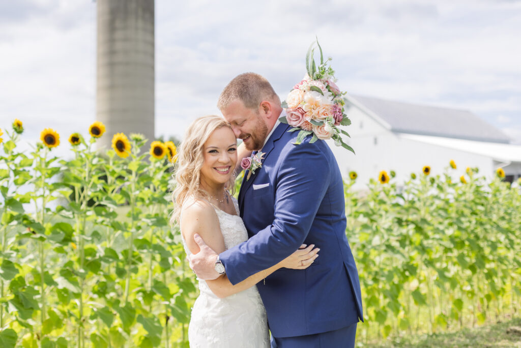 wedding couple standing in front of sunflowers at Arlington Acres venue