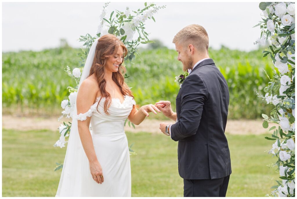 groom placing a ring on the bride's hand during Tiffin, Ohio wedding styled shoot