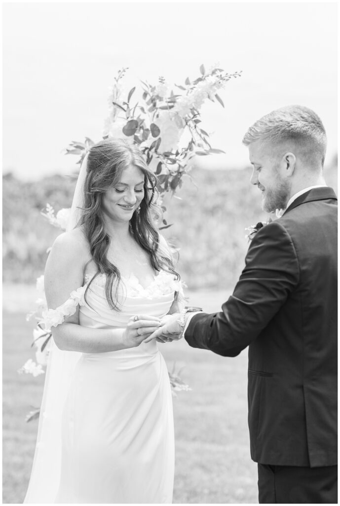 bride placing a ring on the groom's hand during Tiffin, Ohio wedding styled shoo