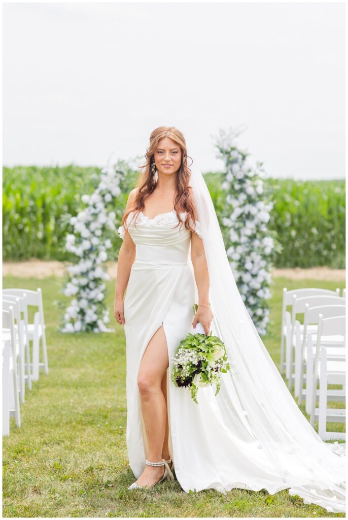 bride posing in the middle of the aisle holding her bouquet