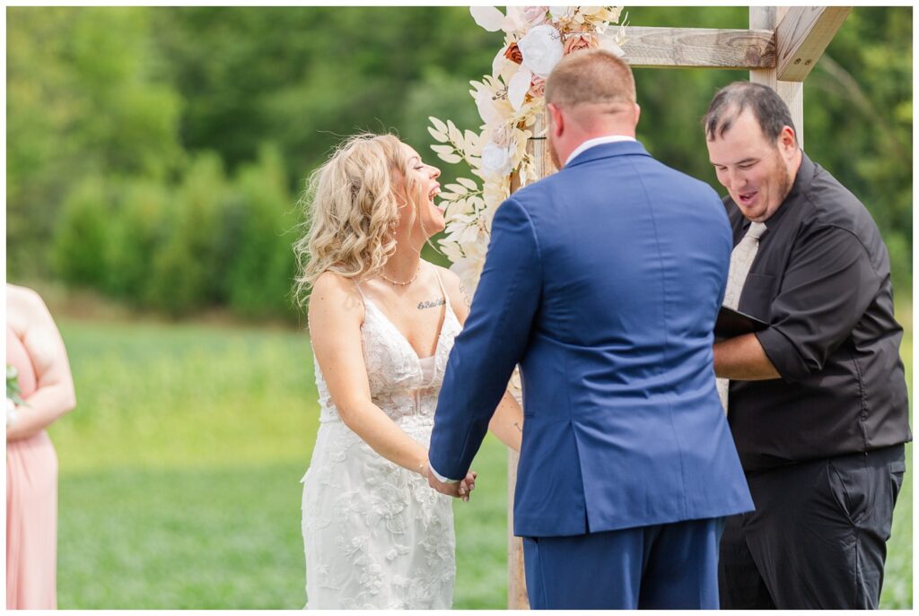 bride laughing at the officiant during the wedding ceremony in Tiffin, Ohio