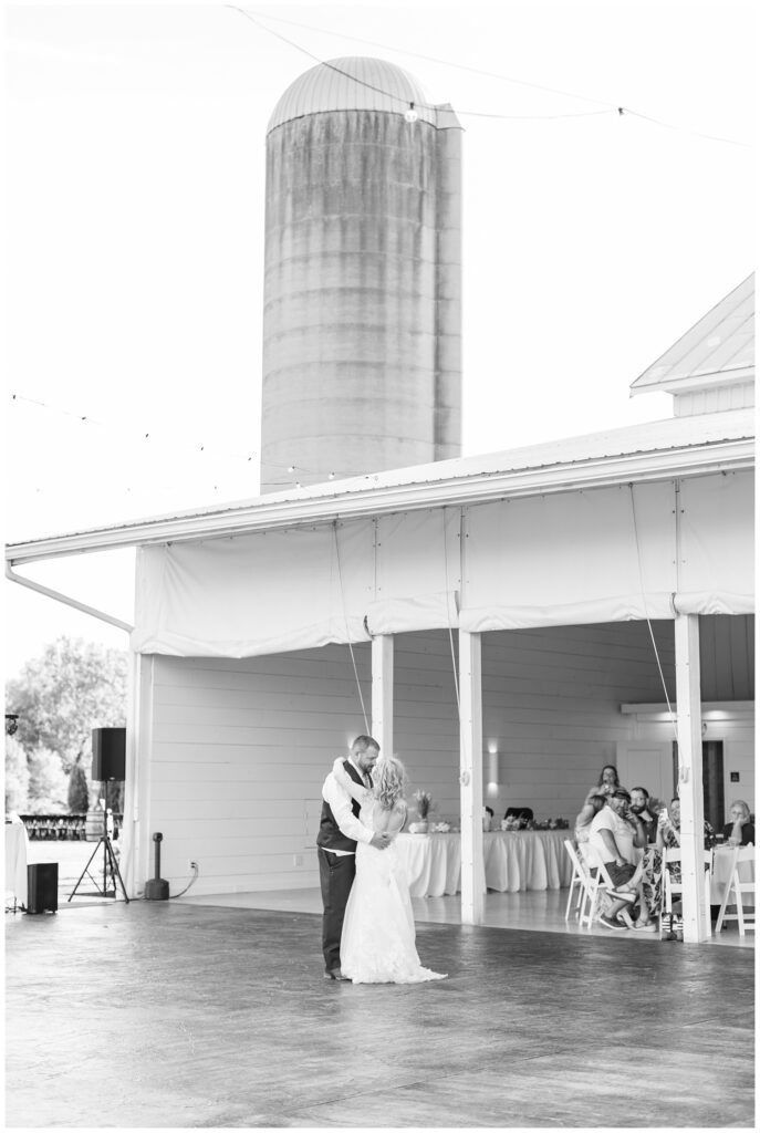 bride having first dance with the groom outside at wedding venue