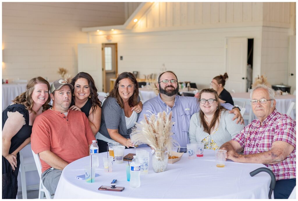 wedding guests posing at their table at Arlington Acres venue