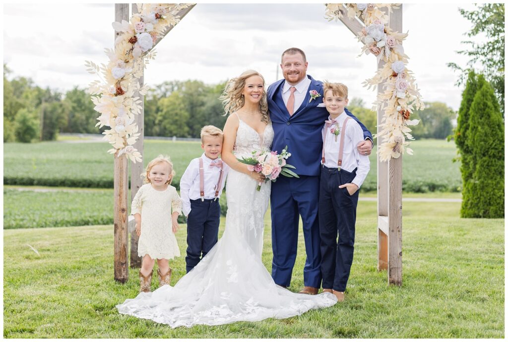 bride and groom posing with their three children at Arlington Acres wedding venue