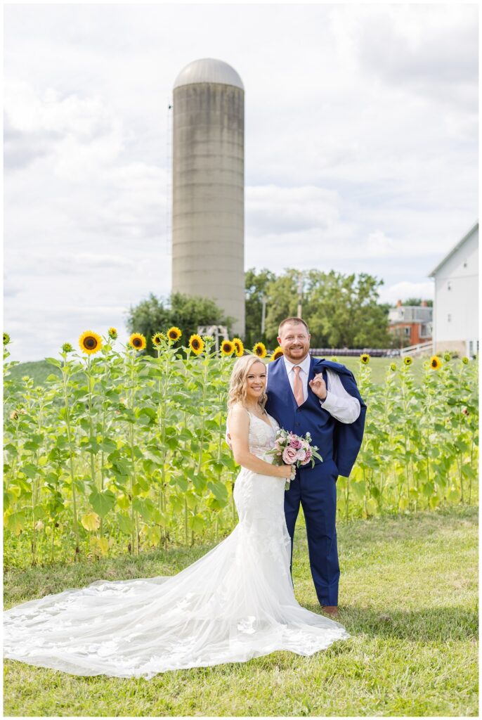 wedding couple posing in front of the sunflowers at Arlington Acres