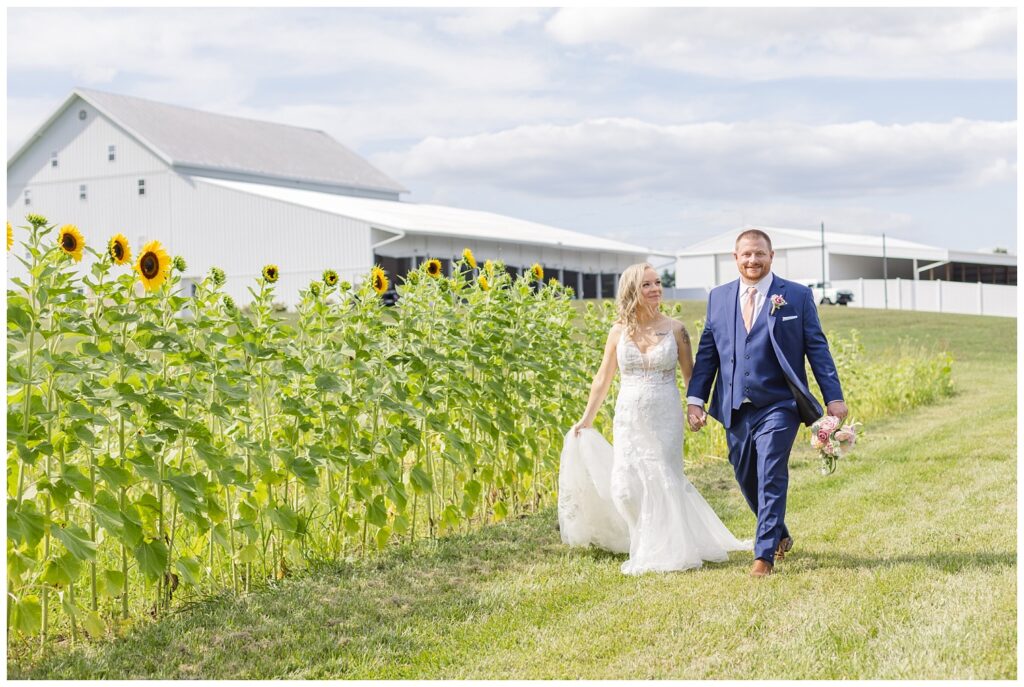 wedding couple walking hand in hand for portraits at Tiffin, Ohio venue