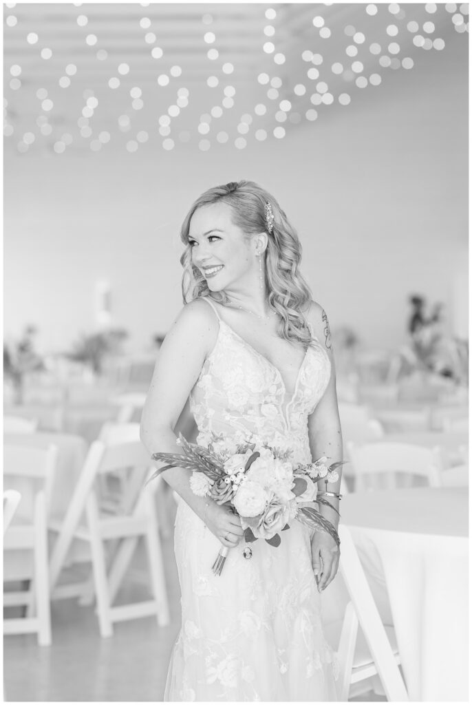 bride posing inside the Arlington Acres wedding venue next to reception tables