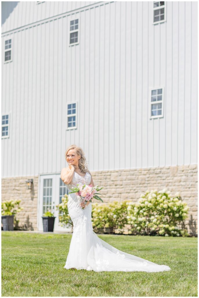 bride posing with her bouquet outside in front of the wedding venue