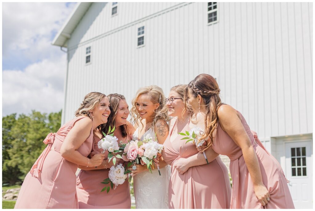 bride and bridesmaids smiling together outside at Arlington Acres venue