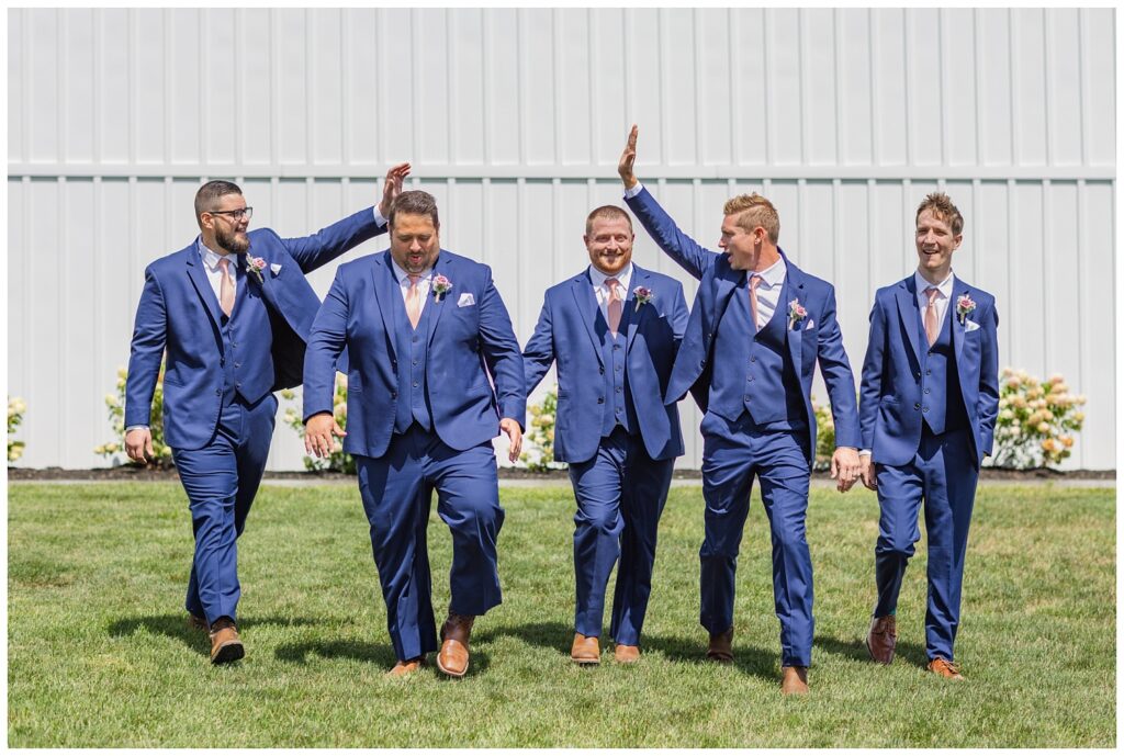 groomsmen walking together and smiling at Arlington Acres venue