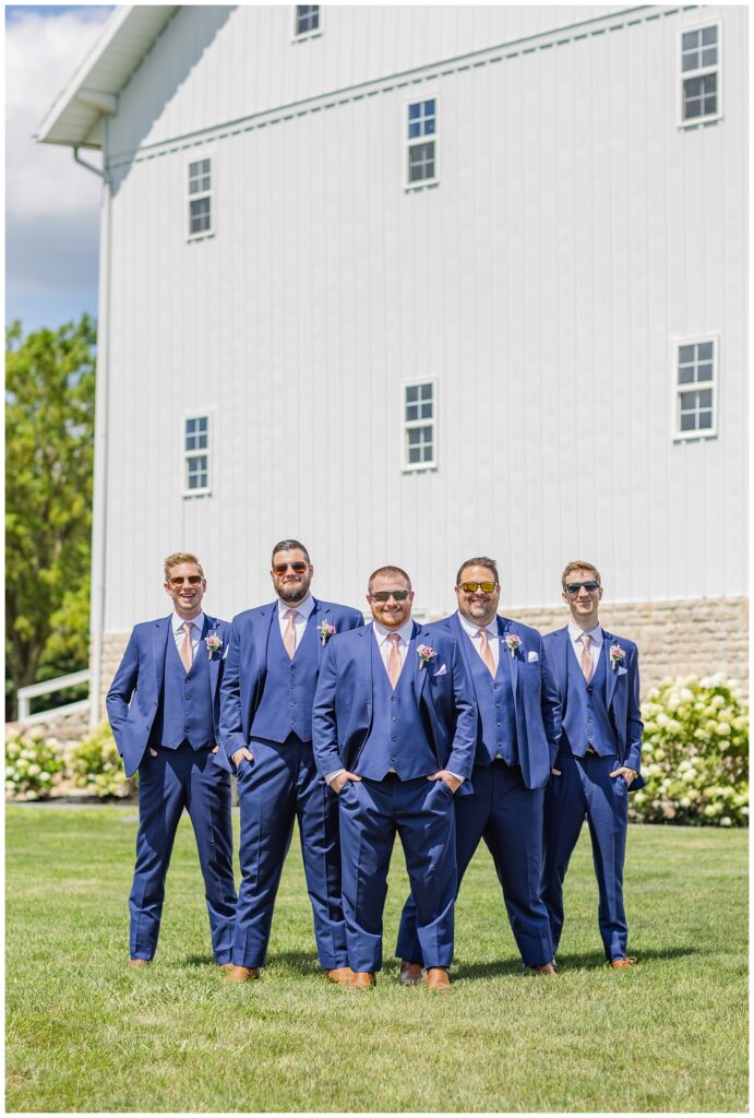 groomsmen posing with their hands in their pockets and wearing sunglasses