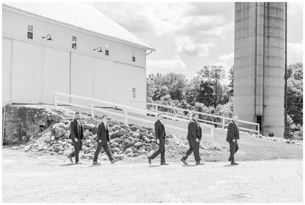 groomsmen walking in a line outside before wedding ceremony