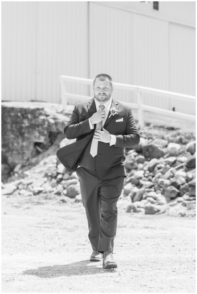 groom adjusting his tie and walking outside before the wedding ceremony