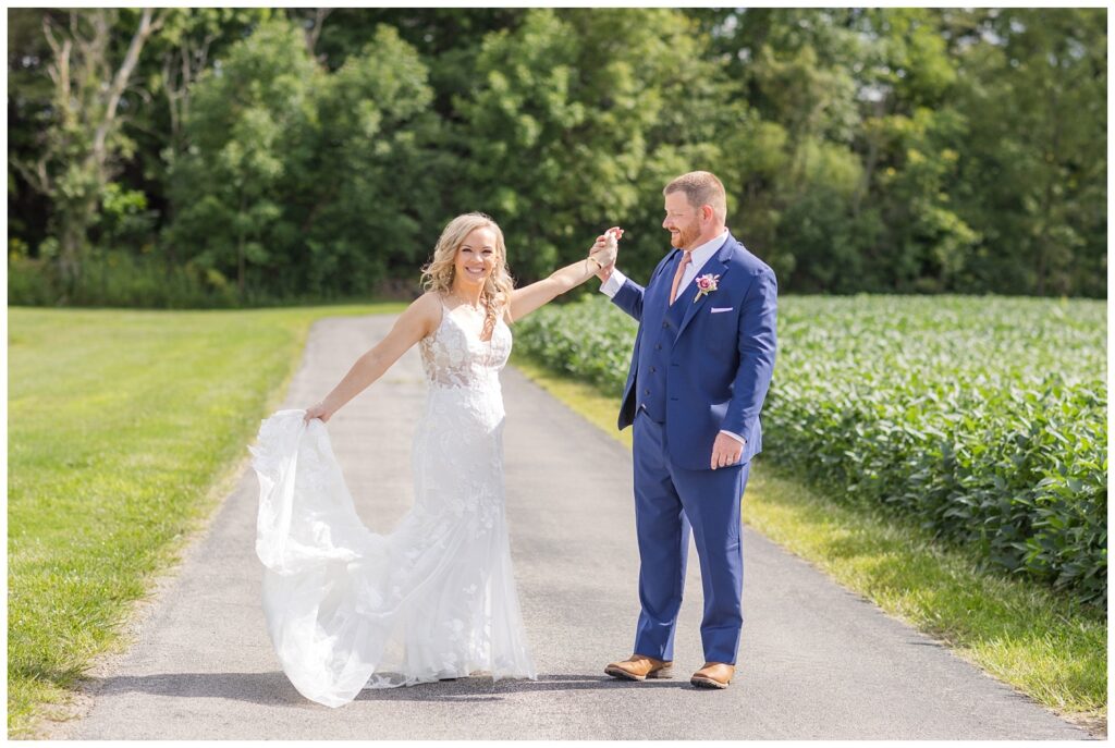 groom twirling the bride on the road at Tiffin, Ohio wedding venue