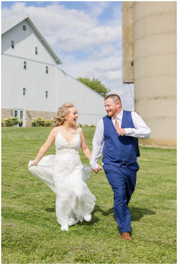 bride and groom running down the hill at Tiffin, Ohio wedding venue