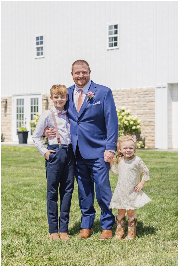 groom posing with his son and stepdaughter after the wedding ceremony