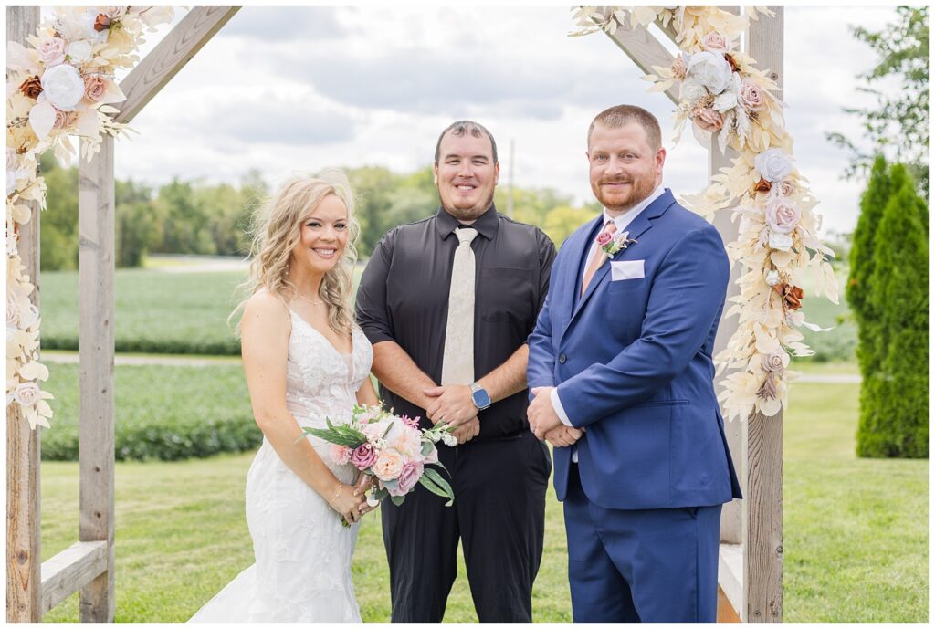 wedding couple posing with the officiant after the ceremony in Tiffin, Ohio