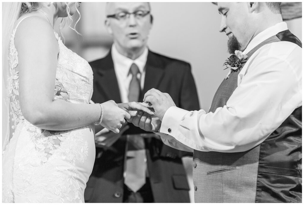 groom placing a ring on the bride's finger during a church ceremony in Ohio