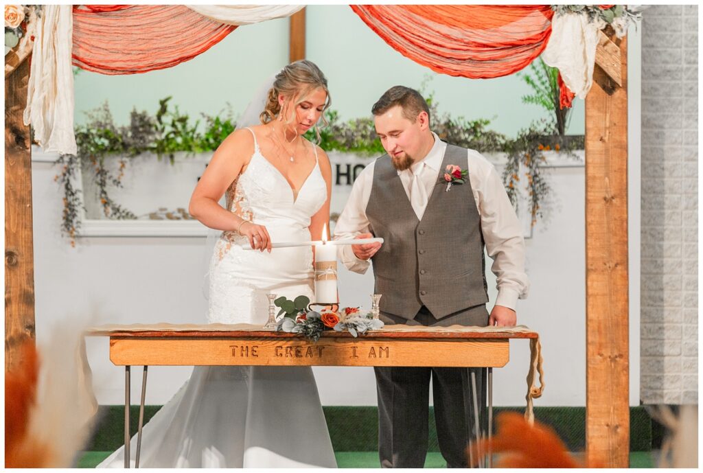 bride and groom lighting a unity candle during the church ceremony in Ohio