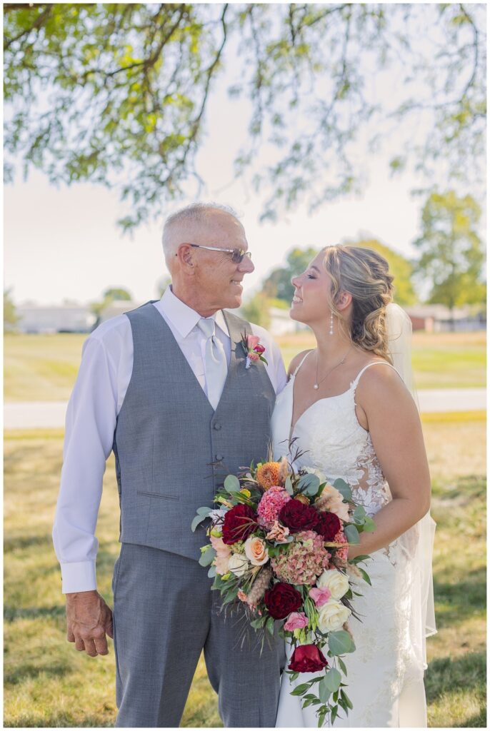 bride posing with her dad outside the church after the wedding ceremony