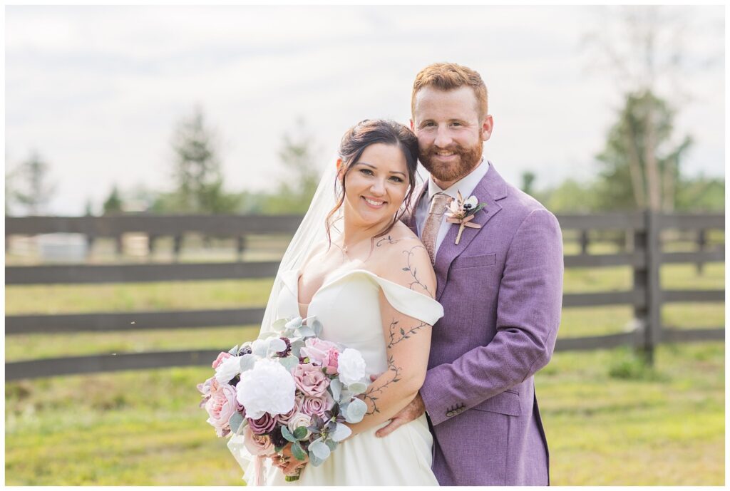 groom hugging the bride from behind while bride holds her bouquet