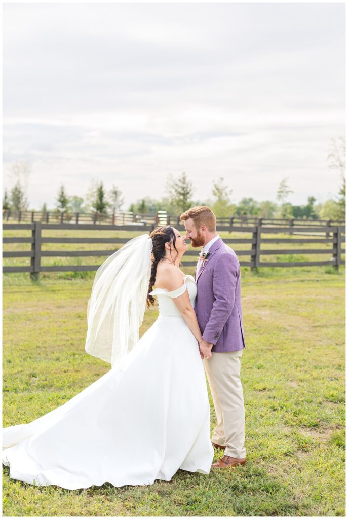 wedding couple holding hands and facing each other smiling outside 