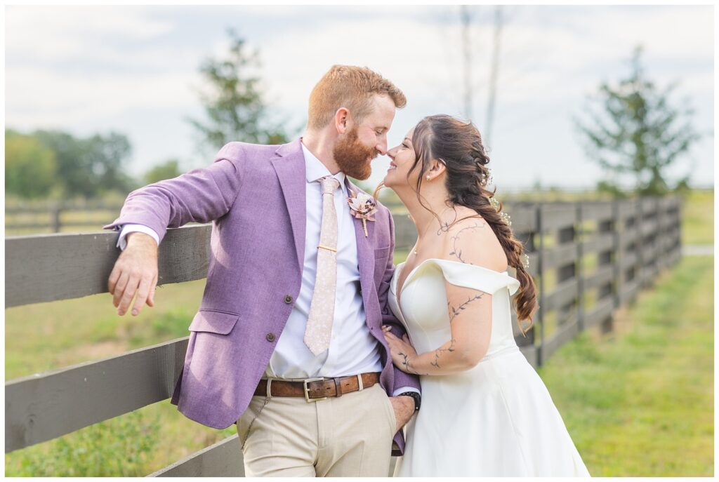 wedding couple leaning against the fence outside at Findlay, Ohio venue