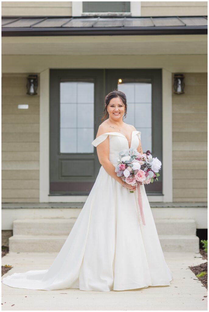 bride posing in front of the venue with  her bouquet in Findlay, Ohio