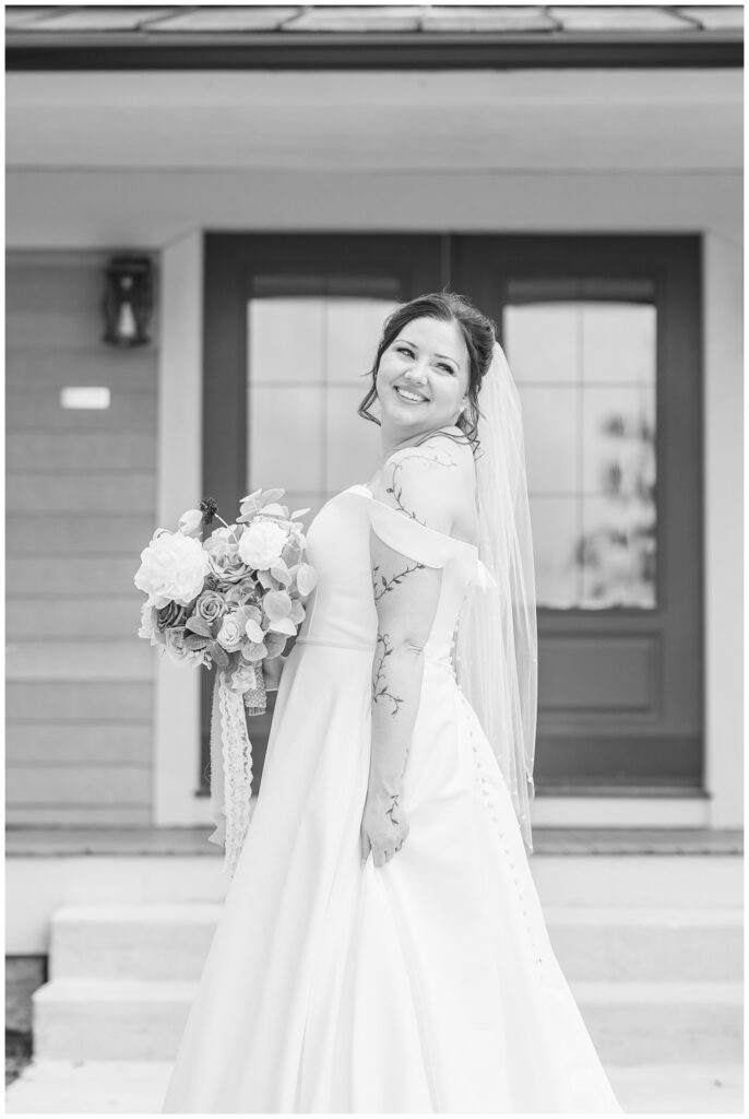 bride posing to the side while looking backwards and holding her bouquet