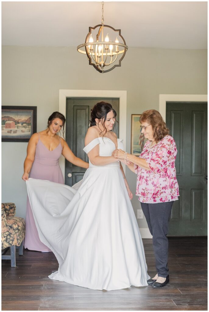 bride's mom putting on her bracelet while getting ready for wedding