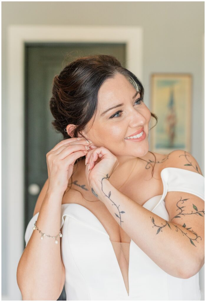 bride adjusting her earrings while getting ready for Findlay, Ohio wedding