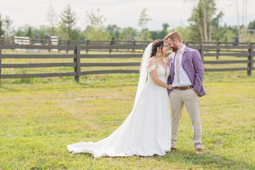 wedding couple posing in front of a fence at Findlay, Ohio venue