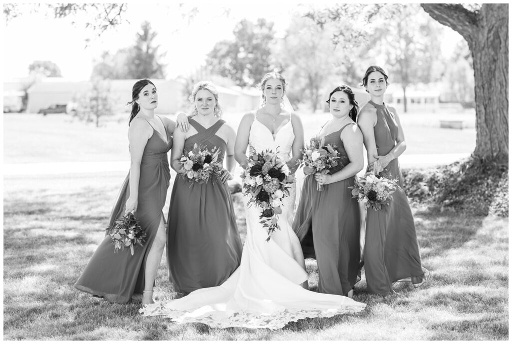 bride posing outside with the bridal party at the church before the ceremony