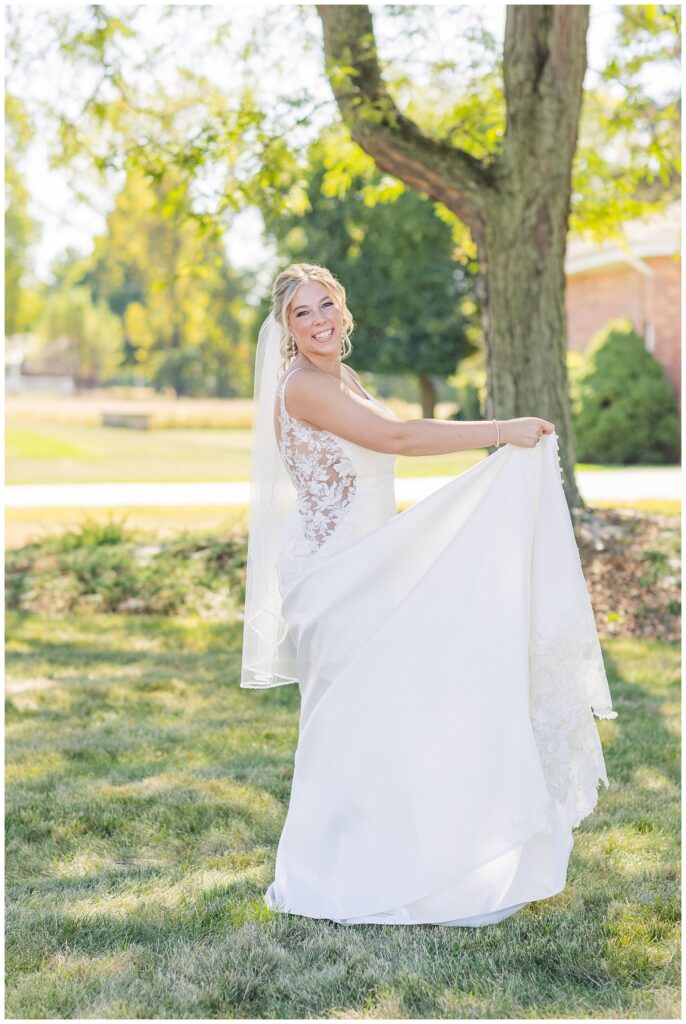 bride holding up the train of her wedding dress after her church ceremony