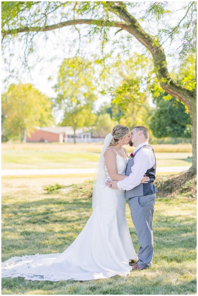 wedding couple sharing a kiss next to a tree in Norwalk, Ohio