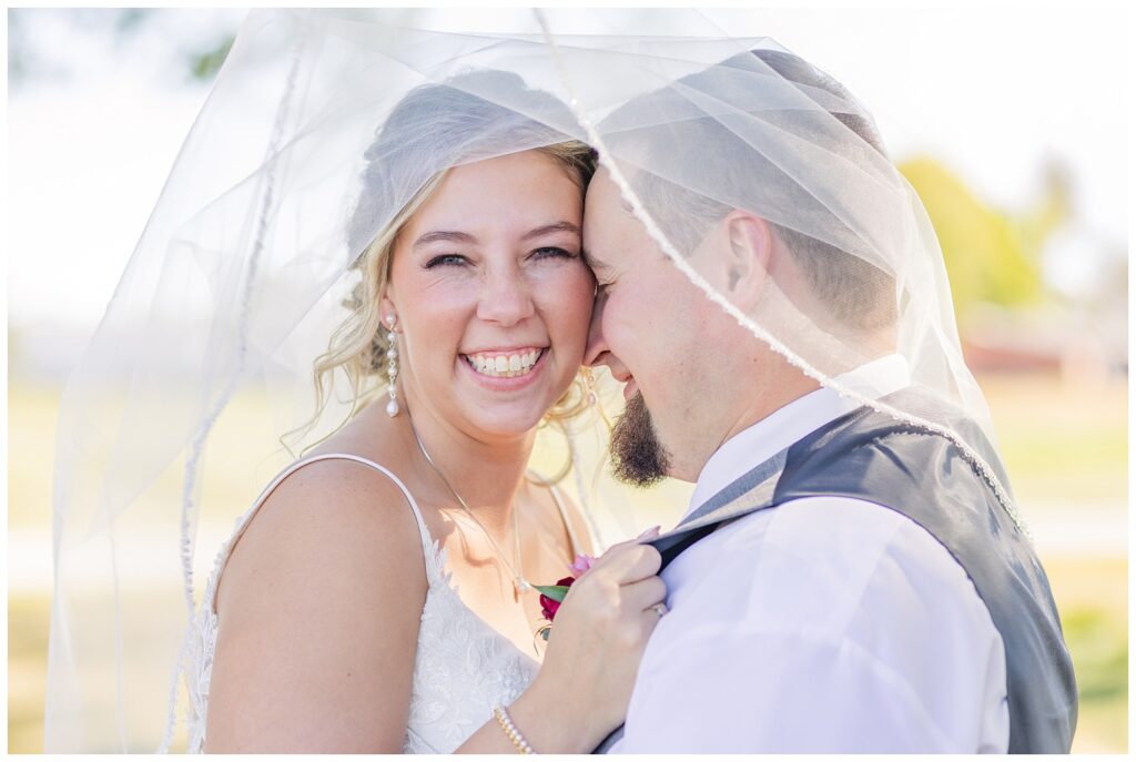 bride and groom posing under the bride's veil at Norwalk, Ohio wedding