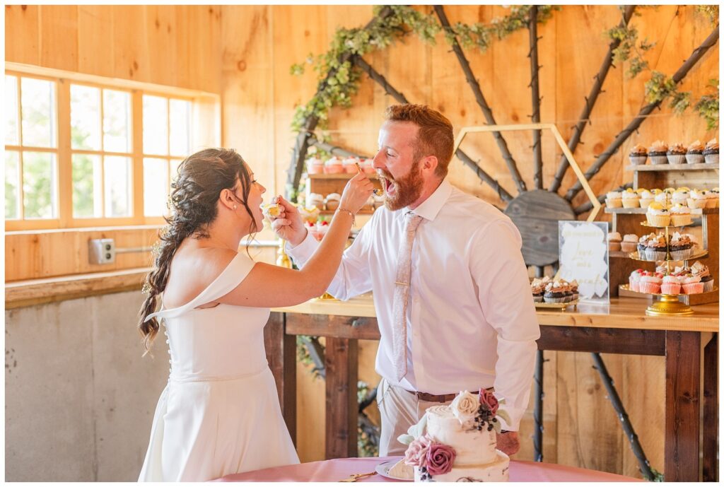 wedding couple feed each other cake during reception at Findlay, Ohio venue