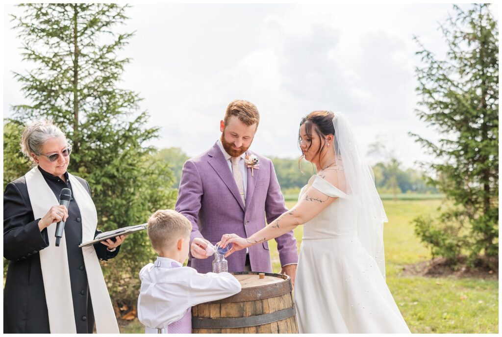 bride and groom pouring sand into a glass jar during unity ceremony 