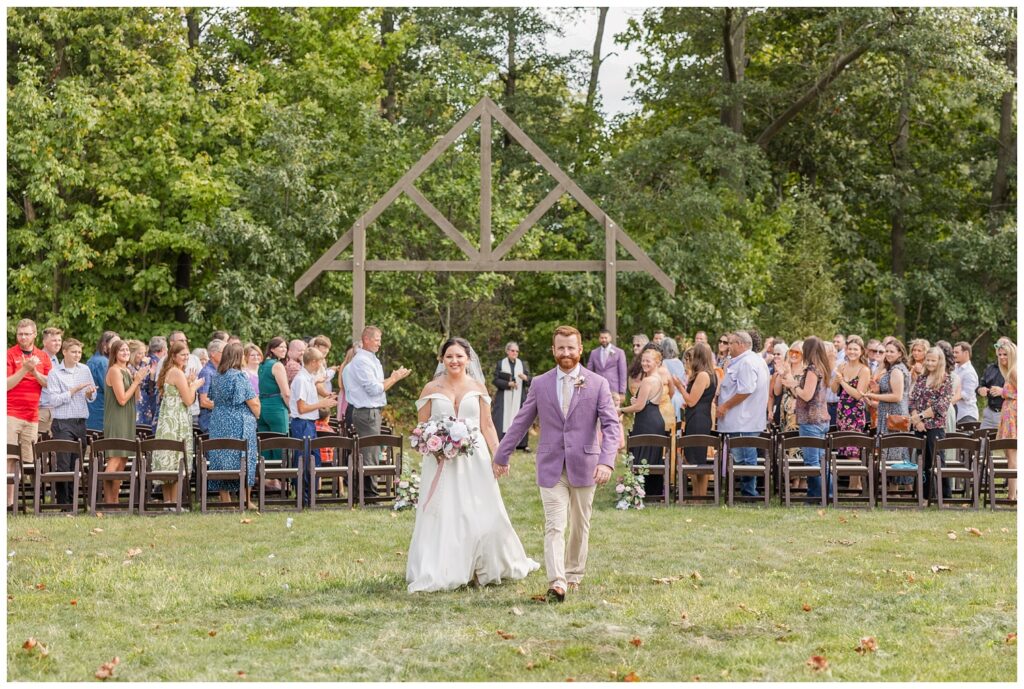 wedding couple walking back down the aisle after outdoors ceremony in northwest Ohio