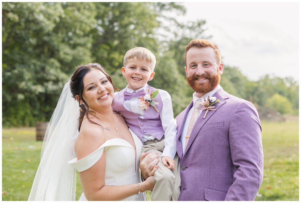 bride, groom, and bride's son posing together after wedding ceremony